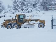 Grader removing snow on Grizzy