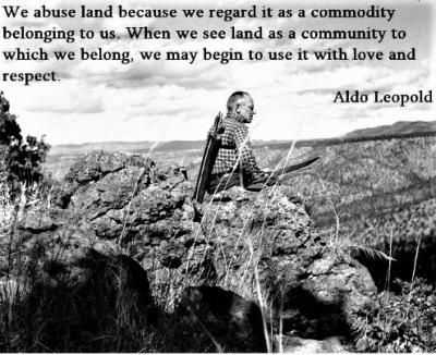 Aldo Leopold sitting on a rock with quote